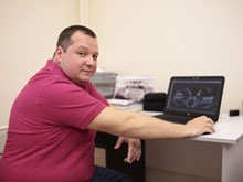 Фото 1 - врач изучает результаты компьютерной томограммы челюсти