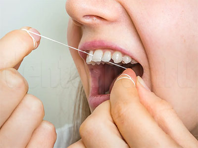 Девушка использует зубную нить